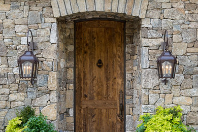 Foto de puerta principal rural con paredes grises, puerta simple, puerta de madera en tonos medios y suelo gris