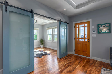 Inspiration for a mid-sized transitional dark wood floor and brown floor entryway remodel in Vancouver with gray walls and a medium wood front door