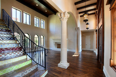 Large tuscan medium tone wood floor entryway photo in Dallas with beige walls and a brown front door