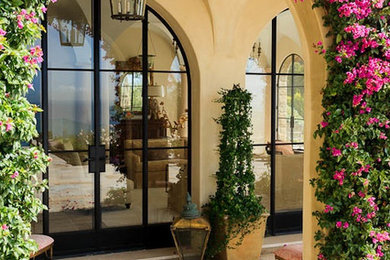 Ejemplo de entrada mediterránea con puerta doble y puerta de vidrio