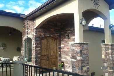 Mid-sized tuscan ceramic tile and beige floor entryway photo in Albuquerque with beige walls and a dark wood front door