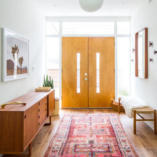 Idee per una porta d'ingresso minimalista con pareti bianche, pavimento in legno massello medio, una porta a due ante, una porta in legno chiaro e pavimento marrone
