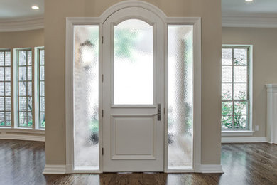 Imagen de puerta principal clásica renovada grande con paredes beige, puerta simple, puerta blanca y suelo de madera oscura