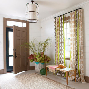 Réalisation d'un hall d'entrée tradition avec un mur blanc, une porte simple, un sol beige et du lambris de bois.