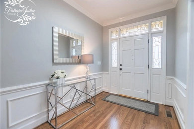 Example of a transitional medium tone wood floor entryway design in Other with gray walls