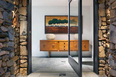 Diseño de puerta principal contemporánea de tamaño medio con puerta pivotante, puerta de vidrio, paredes beige, suelo de pizarra y suelo beige