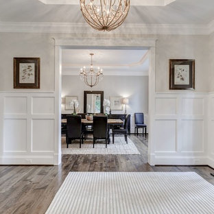Idées déco pour une entrée classique de taille moyenne avec un mur blanc, un sol en contreplaqué, une porte simple et une porte en bois foncé.