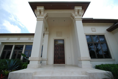 Entryway - large mediterranean marble floor entryway idea in Miami with beige walls and a dark wood front door