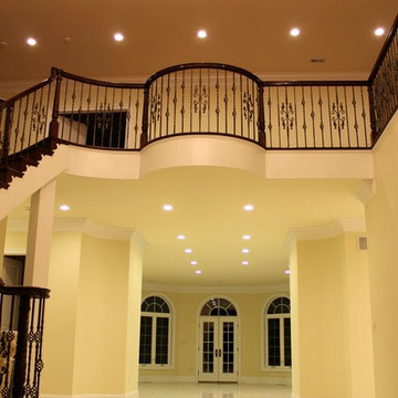 Mediterranean Custom Round Staircase With Iron Balusters & Crystal Chandeliers