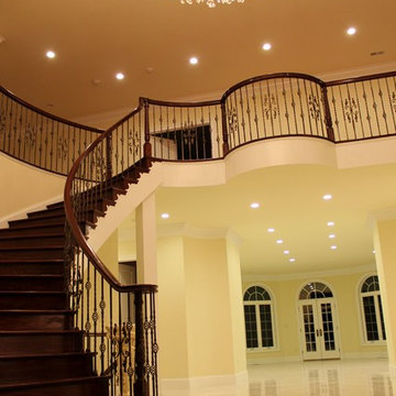 Mediterranean Custom Round Staircase With Iron Balusters & Crystal Chandeliers