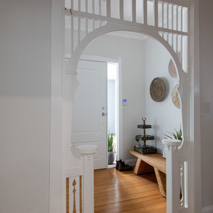 This is an example of a transitional foyer in Newcastle - Maitland with white walls, medium hardwood floors, a single front door, a white front door and brown floor.