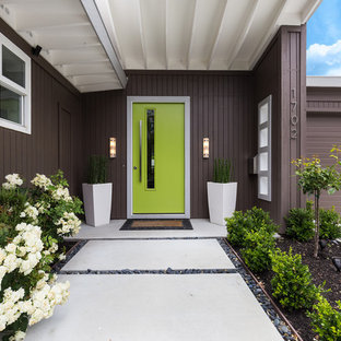 Idee per una porta d'ingresso minimalista con pareti marroni, una porta singola, una porta verde e pavimento giallo