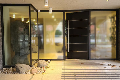 Entryway - contemporary travertine floor and beige floor entryway idea in Toronto with gray walls and a black front door