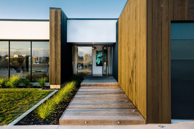 Moderne Haustür mit weißer Wandfarbe, hellem Holzboden, Einzeltür, schwarzer Haustür und braunem Boden in Hamilton