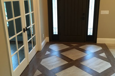 Entryway - mid-sized traditional porcelain tile entryway idea in Orlando with beige walls and a dark wood front door