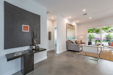 Example of a large minimalist concrete floor and gray floor foyer design in Tampa with white walls