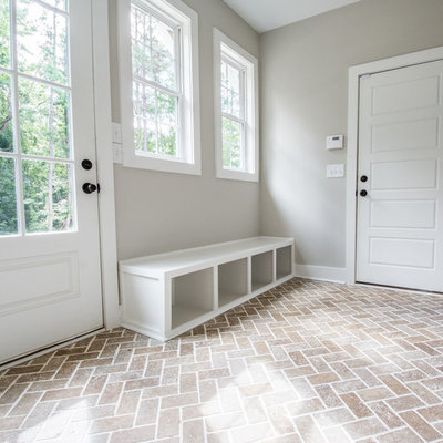 Inspiration for a mid-sized cottage brick floor and brown floor mudroom remodel in Atlanta with gray walls