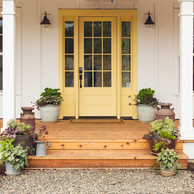 Large farmhouse medium tone wood floor and brown floor entryway photo in Portland with white walls and a yellow front door
