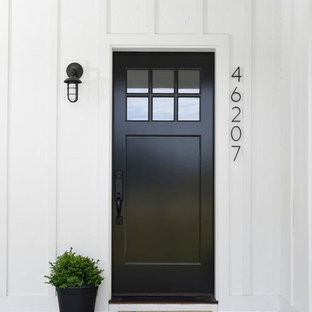 Idee per una porta d'ingresso country con una porta singola e una porta nera