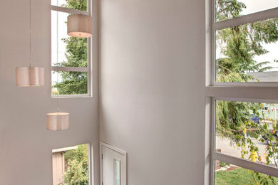 Imagen de distribuidor moderno de tamaño medio con paredes blancas, suelo de madera oscura, puerta simple y puerta blanca