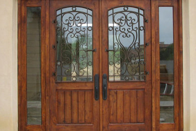 Imagen de puerta principal clásica grande con paredes beige, puerta doble y puerta de madera en tonos medios