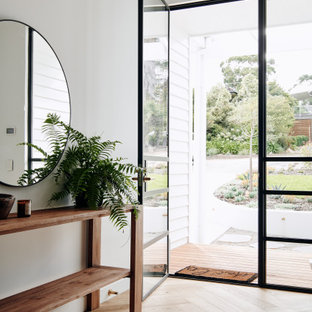 Imagen de distribuidor panelado, contemporáneo, grande, panelado, con paredes blancas, suelo de madera clara, puerta simple, puerta negra, suelo negro y panelado