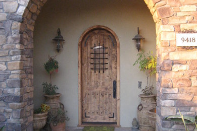 Inspiration for a mid-sized rustic entryway remodel in San Diego with white walls and a medium wood front door
