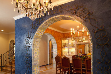 Diseño de distribuidor bohemio con paredes azules, suelo de travertino, puerta simple y puerta de madera en tonos medios
