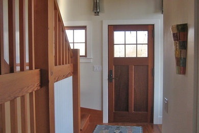 Entryway - mid-sized medium tone wood floor entryway idea in Boston with white walls and a medium wood front door
