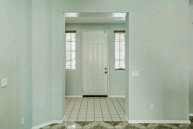 Inspiration for a mid-sized timeless ceramic tile and white floor entryway remodel in Other with a white front door