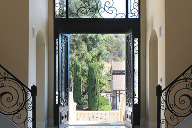 Example of a tuscan entryway design in Los Angeles with yellow walls