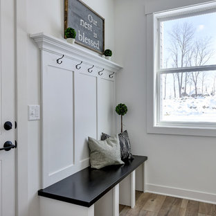 Exemple d'une entrée nature de taille moyenne avec un vestiaire, un mur blanc, sol en stratifié, une porte simple, une porte blanche et un sol gris.