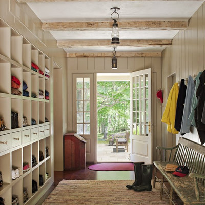Example of a large cottage medium tone wood floor entryway design in New York with gray walls and a white front door