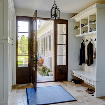 Mudroom Entry with Travertine Flooring and Built-In Cabinetry with Bench Seating