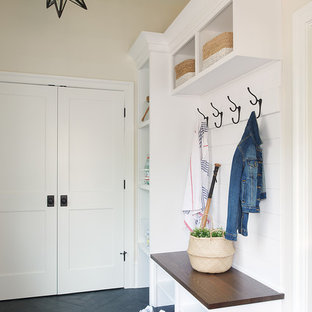 Diseño de vestíbulo posterior costero con paredes beige, suelo negro y suelo de baldosas de porcelana