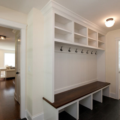 Example of a small country slate floor, black floor and wall paneling entryway design in Chicago with yellow walls and a dark wood front door
