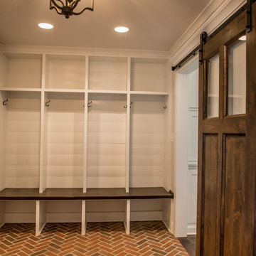 Mudroom with brick floor, white shiplap, and cubbies