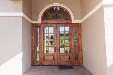 Imagen de puerta principal clásica de tamaño medio con paredes beige, puerta doble y puerta de madera en tonos medios