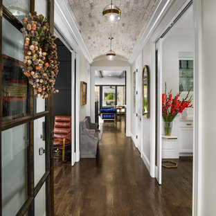 Modelo de hall abovedado, clásico renovado, con paredes grises, suelo de madera oscura, puerta simple, puerta de vidrio y suelo marrón