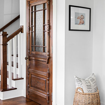 Foyer - cottage dark wood floor and brown floor foyer idea in Nashville with white walls
