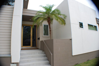 ヒューストンにあるトロピカルスタイルのおしゃれな玄関 (淡色木目調のドア) の写真