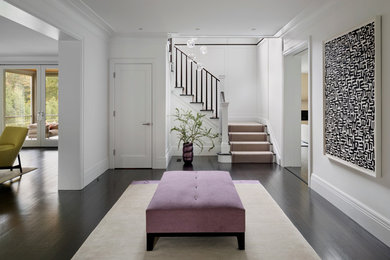 Example of a large transitional dark wood floor foyer design in New York with white walls