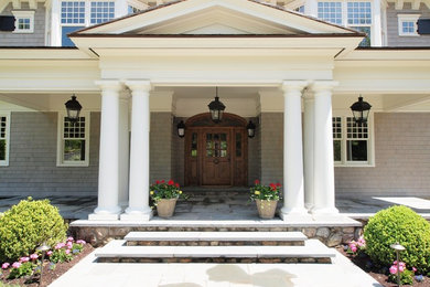 Example of a large classic entryway design in New York with a dark wood front door