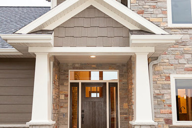 Imagen de puerta principal de estilo americano de tamaño medio con paredes marrones, suelo de cemento, puerta simple y puerta de madera oscura