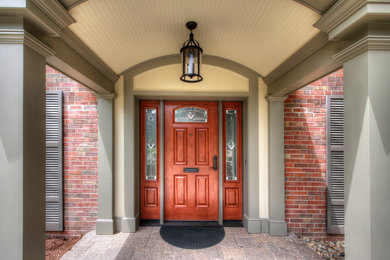 Ejemplo de puerta principal tradicional de tamaño medio con paredes verdes, puerta simple y puerta de madera en tonos medios