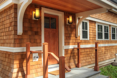 Example of a large classic concrete floor entryway design in Boston with brown walls and a medium wood front door
