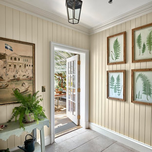 Immagine di un grande ingresso con anticamera tradizionale con pareti beige, una porta singola, una porta in vetro, pavimento in cemento e pavimento grigio