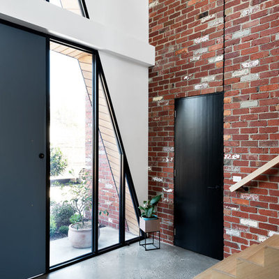 Mid-sized trendy concrete floor and gray floor entryway photo in Melbourne with a black front door and white walls