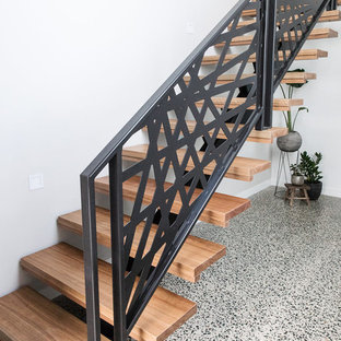 Idée de décoration pour une porte d'entrée minimaliste de taille moyenne avec un mur blanc, un sol en liège, une porte simple, une porte en bois brun et un sol gris.