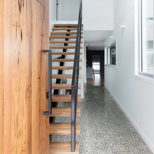 Esempio di una porta d'ingresso moderna di medie dimensioni con pareti bianche, pavimento in sughero, una porta singola, una porta in legno bruno e pavimento grigio